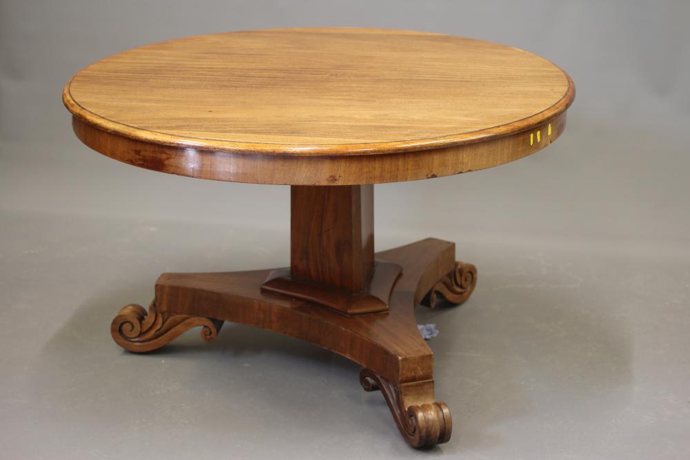 A VICTORIAN MAHOGANY CENTRE TABLE, the moulded edged circular tilt top on triangular stem concave Image