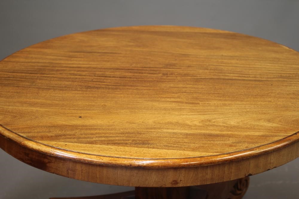 A VICTORIAN MAHOGANY CENTRE TABLE, the moulded edged circular tilt top on triangular stem concave Image