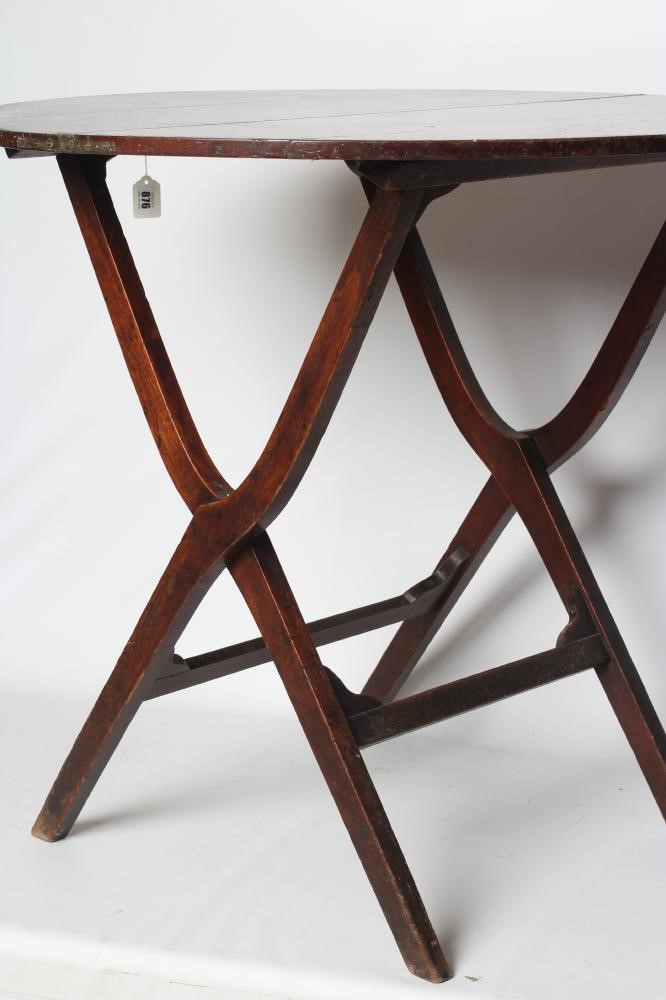 A MAHOGANY CAMPAIGN TABLE, early 19th century, the circular hinged top raised on shaped square Image
