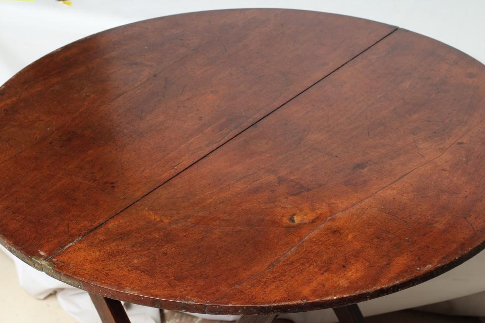A MAHOGANY CAMPAIGN TABLE, early 19th century, the circular hinged top raised on shaped square Image