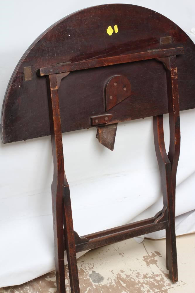 A MAHOGANY CAMPAIGN TABLE, early 19th century, the circular hinged top raised on shaped square Image