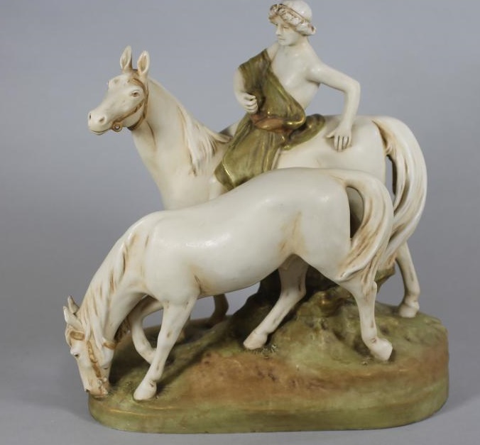 A ROYAL DUX PORCELAIN GROUP modelled as a young man wearing a green draped tunic seated astride a Image