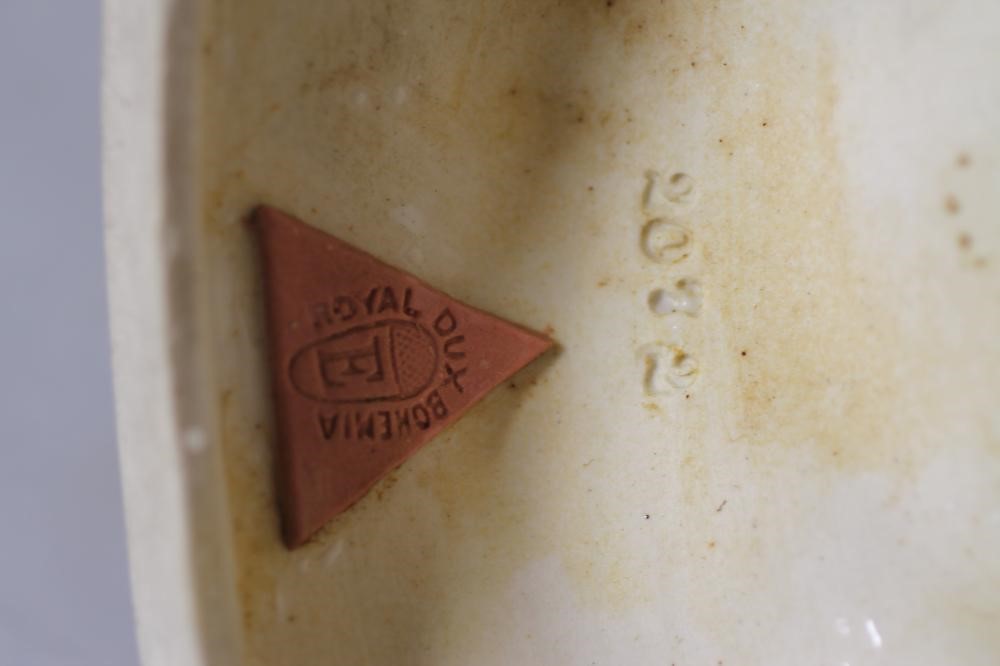 A ROYAL DUX PORCELAIN GROUP modelled as a young man wearing a green draped tunic seated astride a Image