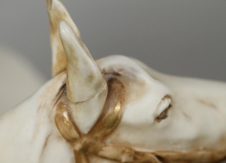 A ROYAL DUX PORCELAIN GROUP modelled as a young man wearing a green draped tunic seated astride a Image