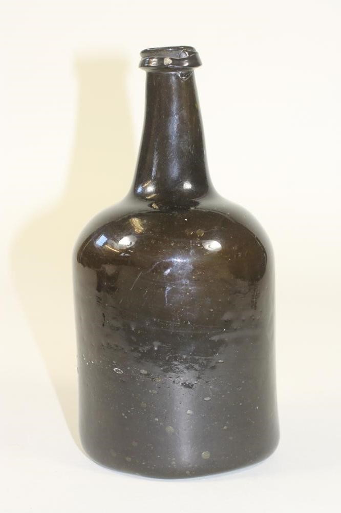 A DARK GREEN GLASS BOTTLE Image