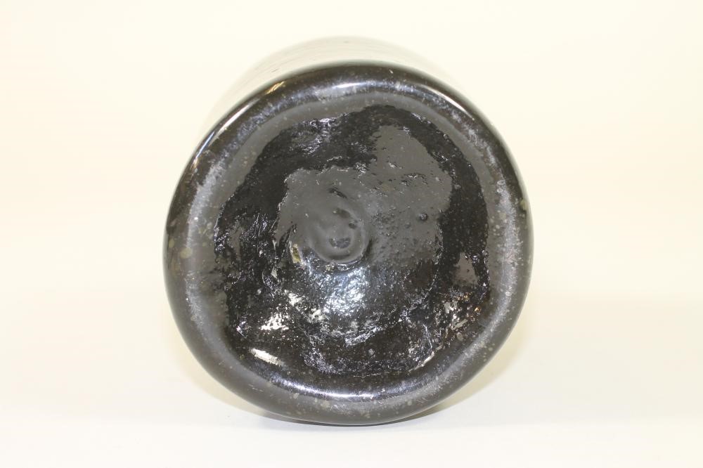 A DARK GREEN GLASS BOTTLE Image