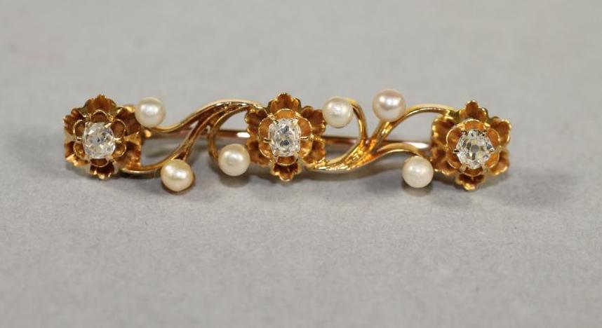 A DIAMOND AND PEARL BROOCH of oblong scroll form claw set with three old cut diamonds and six pearls Image