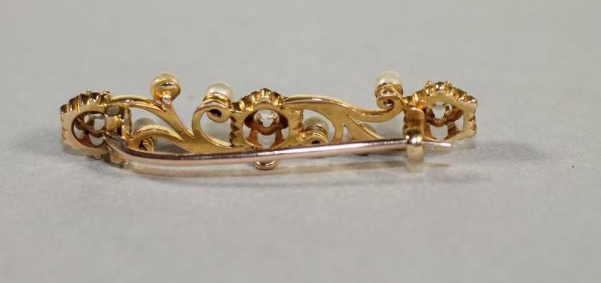 A DIAMOND AND PEARL BROOCH of oblong scroll form claw set with three old cut diamonds and six pearls Image