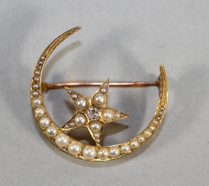 A VICTORIAN 15CT GOLD CRESCENT AND STAR BROOCH inset with graduated split seed pearls Image