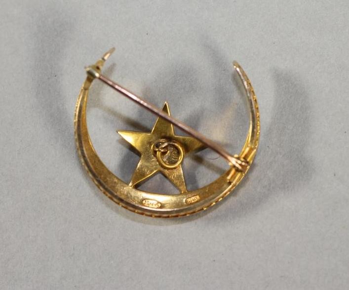 A VICTORIAN 15CT GOLD CRESCENT AND STAR BROOCH inset with graduated split seed pearls Image
