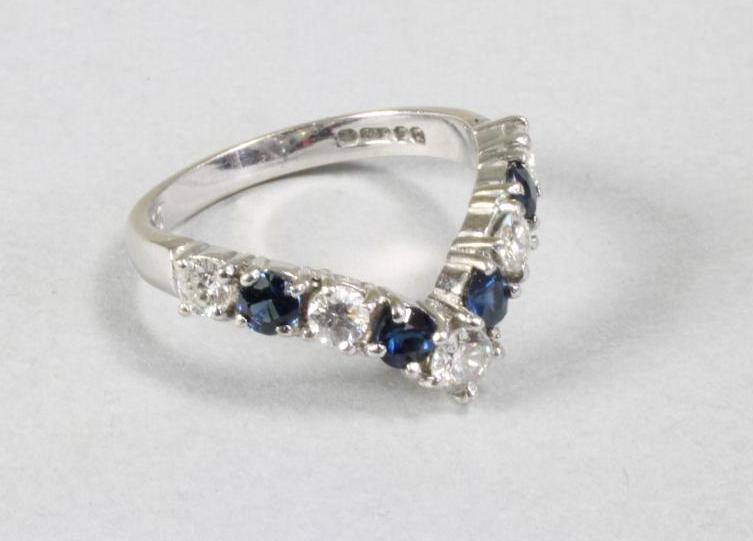 A SAPPHIRE AND DIAMOND HALF HOOP ETERNITY RING of "V" form claw set with five brilliant cut diamonds Image