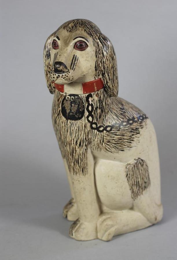 A VICTORIAN NAIVE SOFTWOOD CARVED AND PAINTED SPANIEL Image