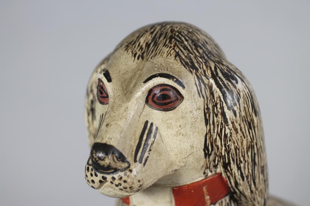 A VICTORIAN NAIVE SOFTWOOD CARVED AND PAINTED SPANIEL Image