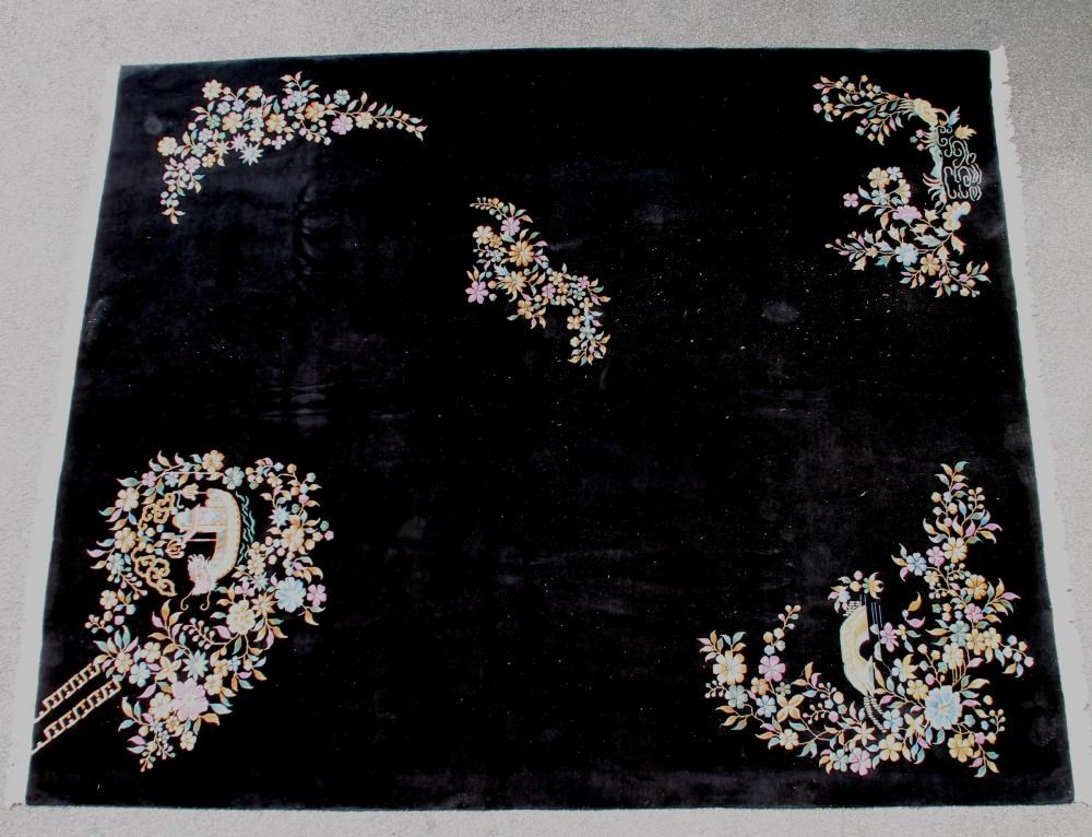 A CHINESE WASHED AND FRINGED BLACK GROUND CARPET with central polychrome floral spray and similar Image