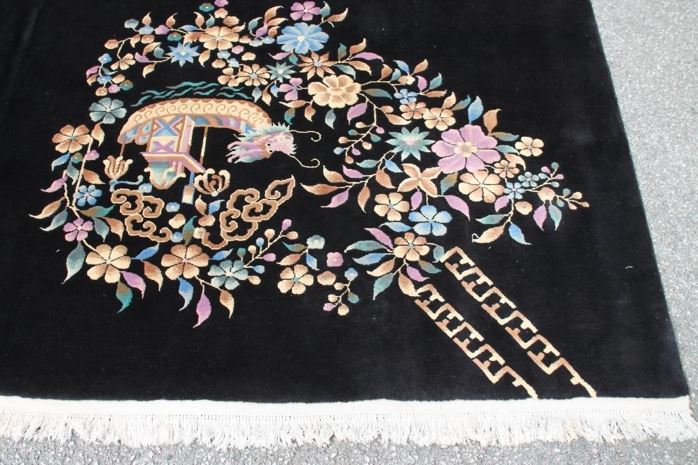 A CHINESE WASHED AND FRINGED BLACK GROUND CARPET with central polychrome floral spray and similar Image