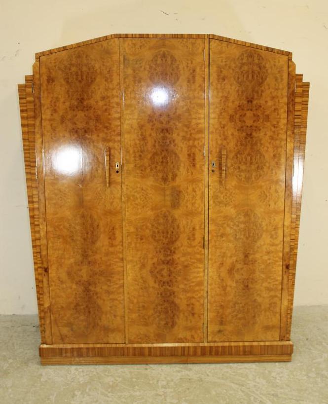 AN ART DECO BURR MAPLE VENEERED TRIPLE WARDROBE of arched stepped tapering form with zebra wood Image