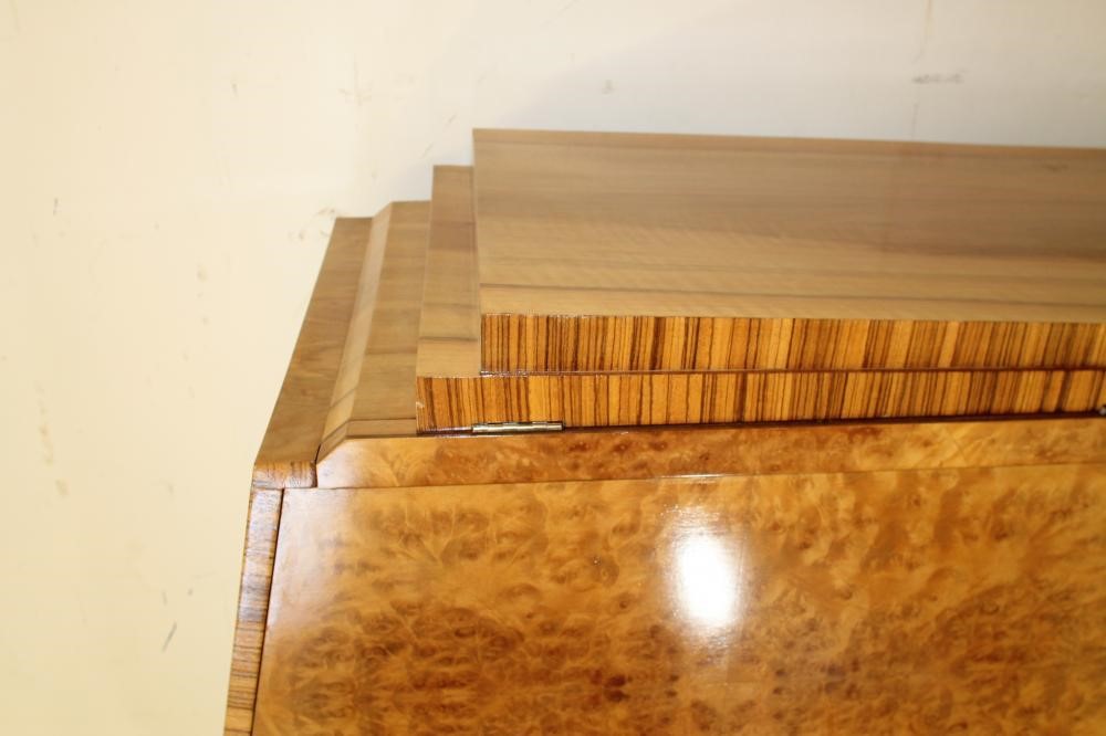 AN ART DECO BURR MAPLE VENEERED TRIPLE WARDROBE of arched stepped tapering form with zebra wood Image