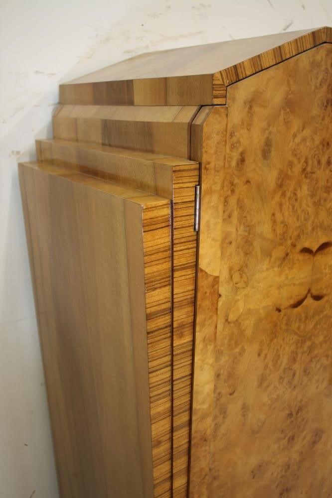 AN ART DECO BURR MAPLE VENEERED TRIPLE WARDROBE of arched stepped tapering form with zebra wood Image