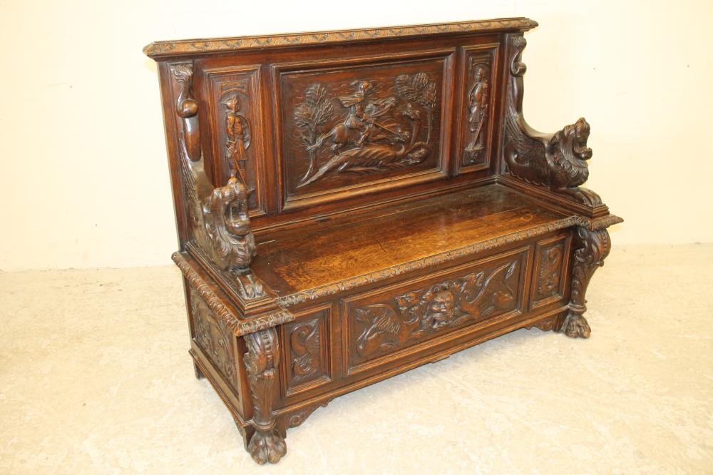 A LATE VICTORIAN CARVED OAK SETTLE Image