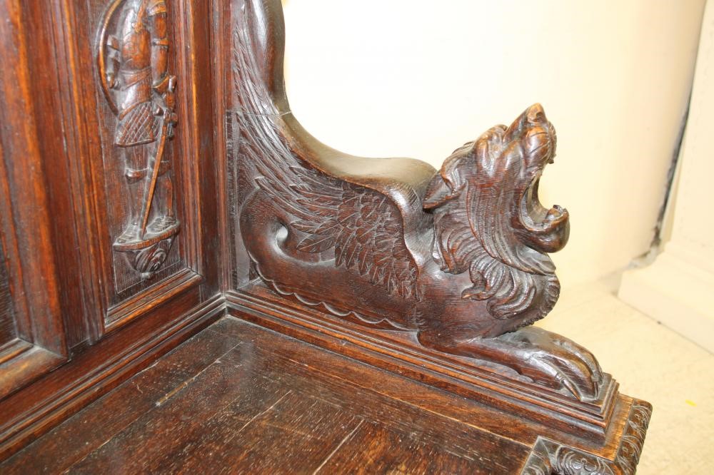 A LATE VICTORIAN CARVED OAK SETTLE Image