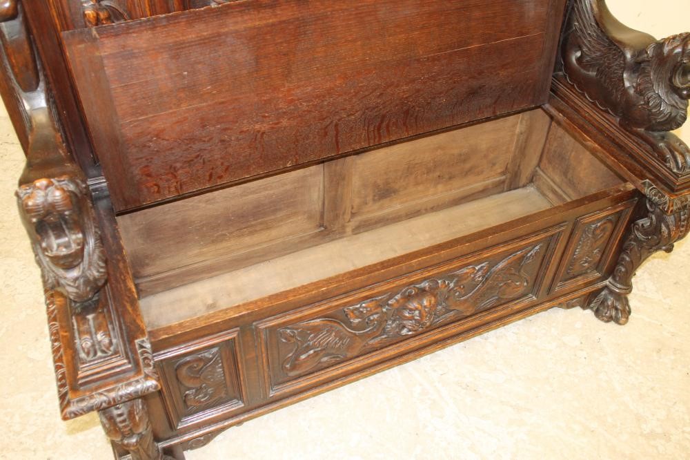 A LATE VICTORIAN CARVED OAK SETTLE Image
