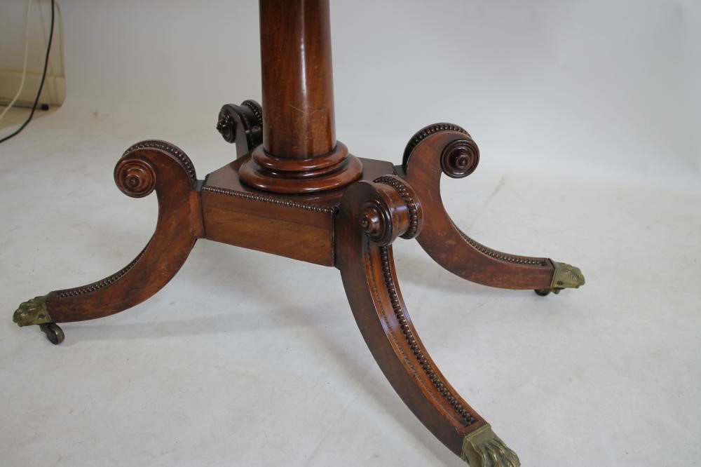 A REGENCY MAHOGANY FOLDING CARD TABLE of rounded oblong form with stringing and beaded edging Image