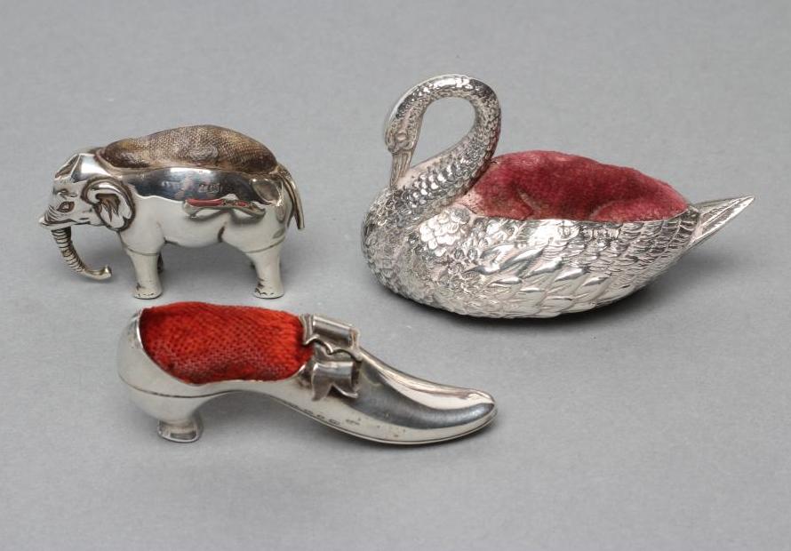 THREE NOVELTY SILVER PIN CUSHIONS comprising a shoe with bow and buckle on a Louis heel Image