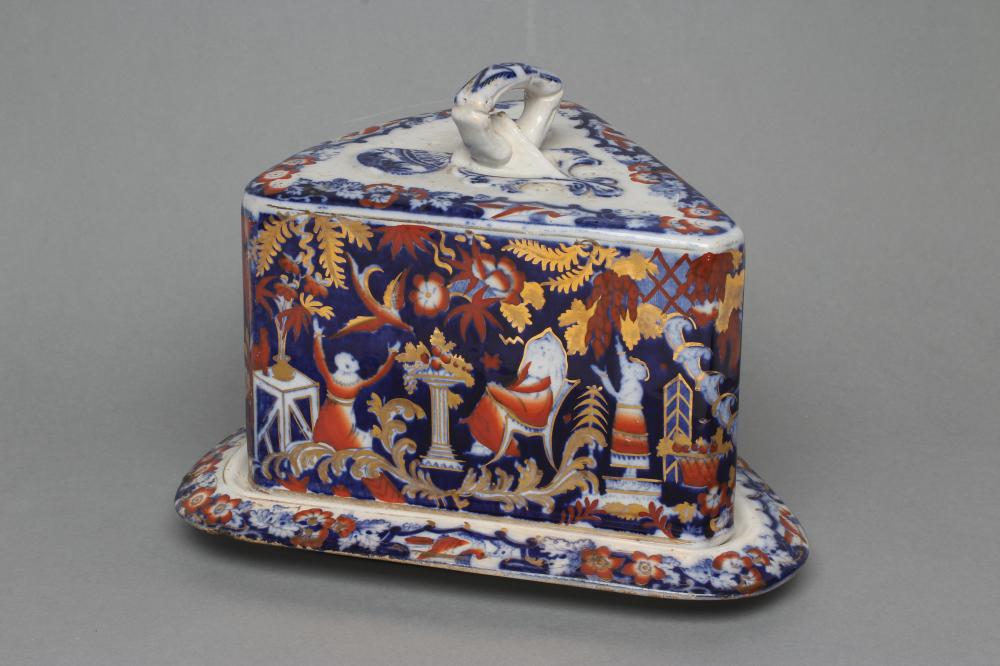 A VICTORIAN STAFFORDSHIRE POTTERY CHEESE WEDGE AND STAND printed in underglaze blue and overpainted Image