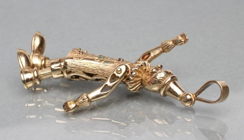 A 9CT GOLD ARTICULATED CLOWN PENDANT with ruby eyes Image