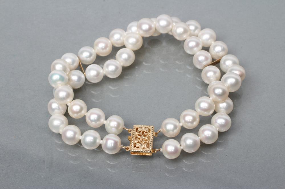 A TWO ROW CULTURED PEARL BRACELET with two fixed spacers between and foliate pierced clasp Image