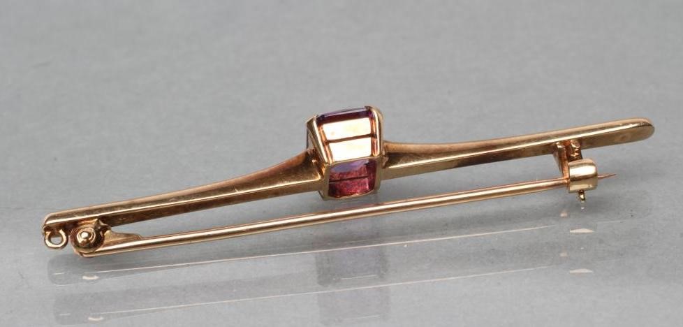 AN EDWARDIAN PROPELLOR BAR BROOCH centred by an oblong facet cut amethyst Image
