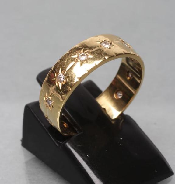 A DIAMOND SET 18CT GOLD WEDDING RING set with diamond points to foliate engraving Image