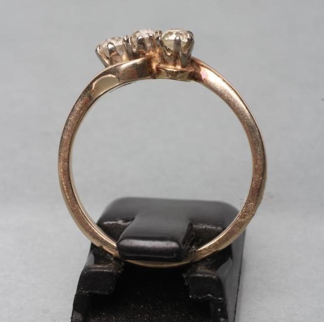 A THREE STONE DIAMOND CROSSOVER RING Image