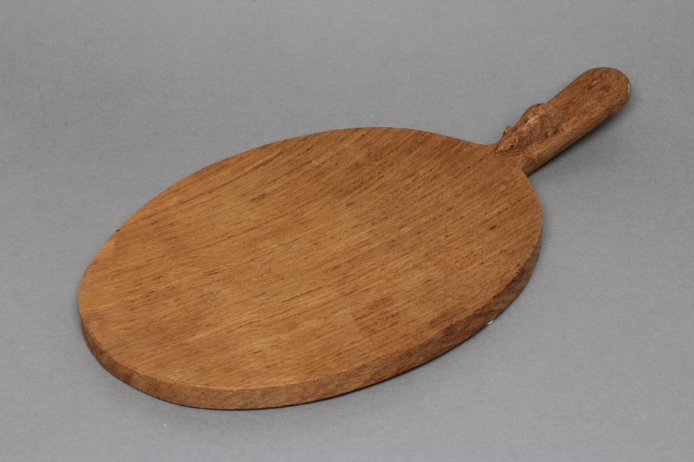 A ROBERT THOMPSON ADZED OAK CHEESE BOARD of oval form Image