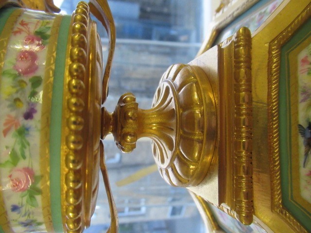 A FRENCH GILT METAL AND INSET PORCELAIN CLOCK GARNITURE Image