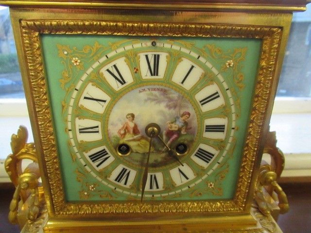 A FRENCH GILT METAL AND INSET PORCELAIN CLOCK GARNITURE Image
