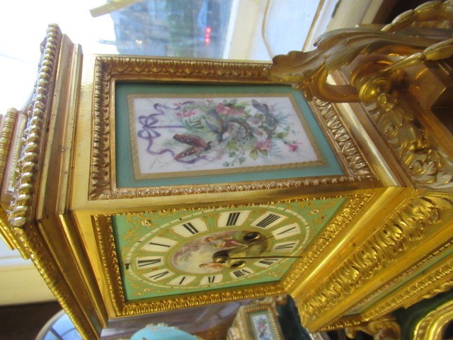 A FRENCH GILT METAL AND INSET PORCELAIN CLOCK GARNITURE Image