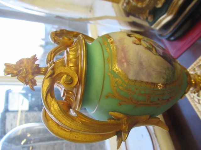 A FRENCH GILT METAL AND INSET PORCELAIN CLOCK GARNITURE Image