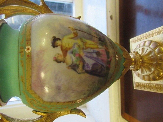 A FRENCH GILT METAL AND INSET PORCELAIN CLOCK GARNITURE Image