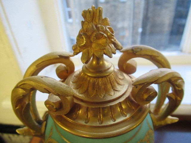 A FRENCH GILT METAL AND INSET PORCELAIN CLOCK GARNITURE Image