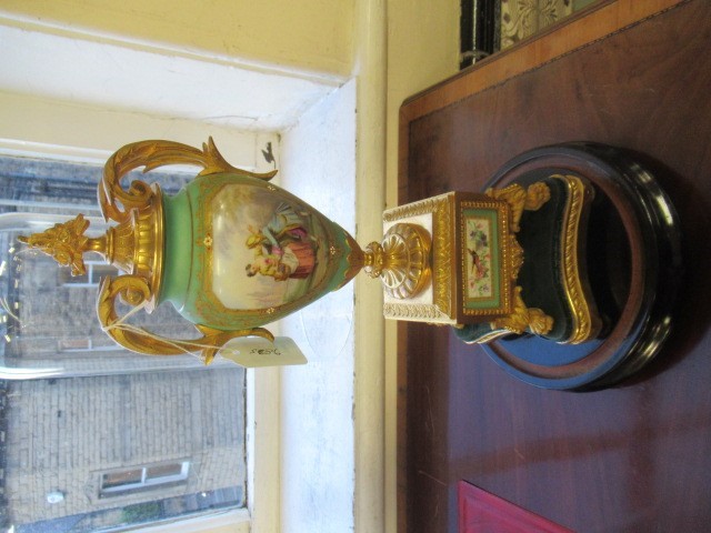 A FRENCH GILT METAL AND INSET PORCELAIN CLOCK GARNITURE Image