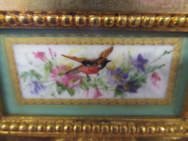 A FRENCH GILT METAL AND INSET PORCELAIN CLOCK GARNITURE Image