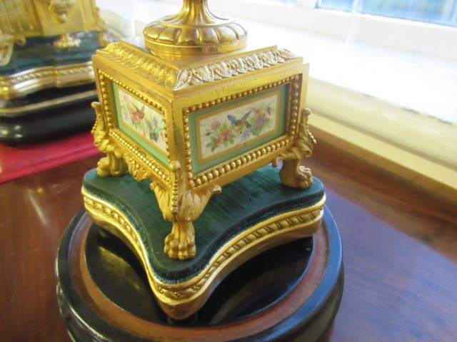 A FRENCH GILT METAL AND INSET PORCELAIN CLOCK GARNITURE Image