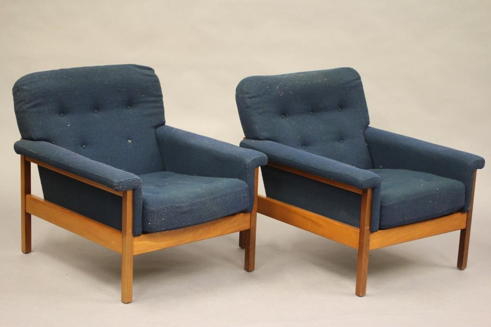A GUY ROGERS TEAK LOUNGE SUITE comprising a pair of arm chairs button upholstered in deep blue tweed Image