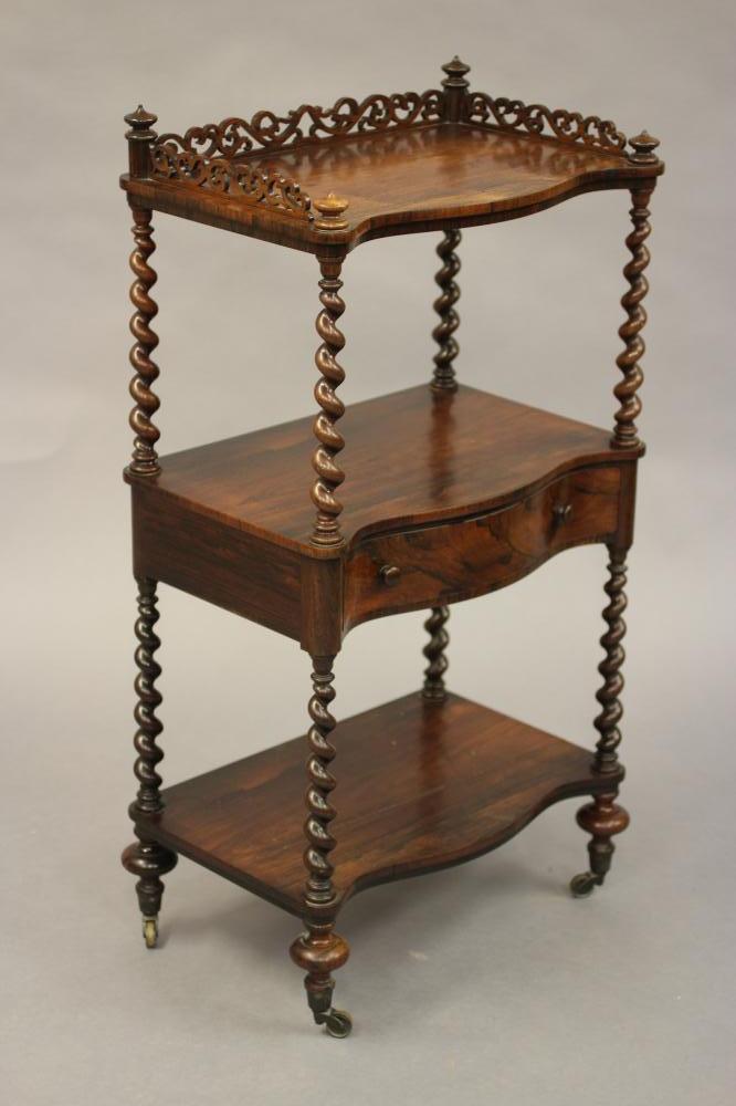 A VICTORIAN ROSEWOOD THREE TIER WHATNOT of oblong serpentine form with pierced gallery Image