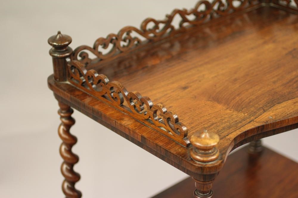 A VICTORIAN ROSEWOOD THREE TIER WHATNOT of oblong serpentine form with pierced gallery Image