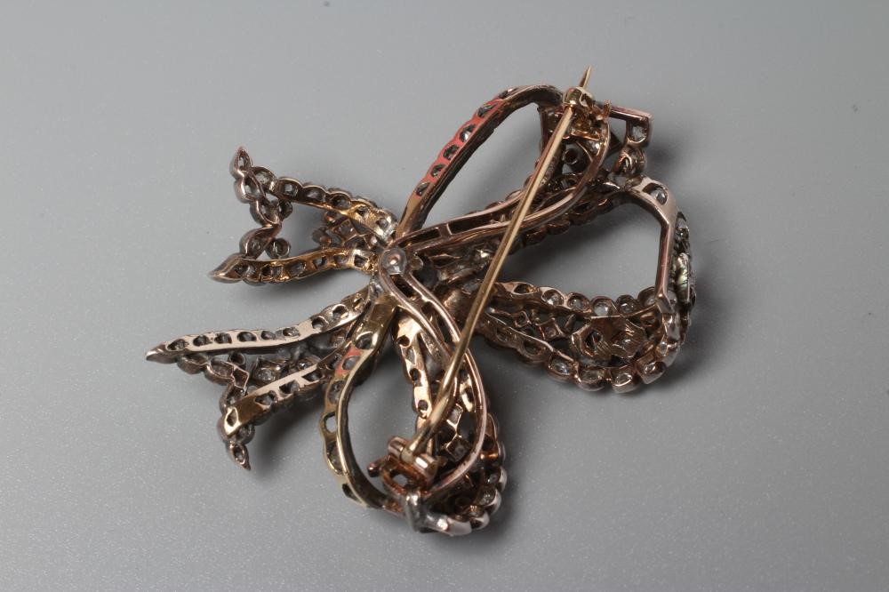 A VICTORIAN DIAMOND BOW BROOCH centred by an old cut stone of approximately 0.4cts and multi stone Image