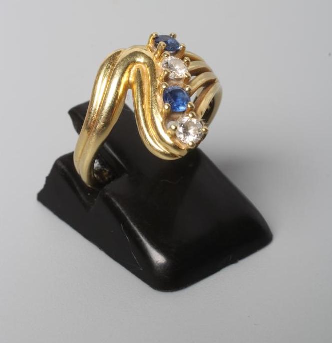A FOUR STONE SAPPHIRE AND DIAMOND CROSSOVER DRESS RING Image