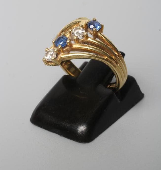 A FOUR STONE SAPPHIRE AND DIAMOND CROSSOVER DRESS RING Image