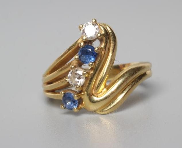 A FOUR STONE SAPPHIRE AND DIAMOND CROSSOVER DRESS RING Image
